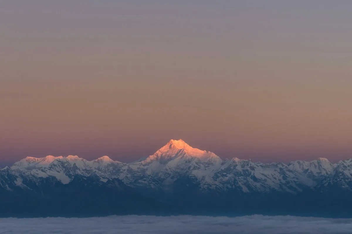 Sikkim Travel Service – Kangchenjunga turning pink at first light above a dark ridge