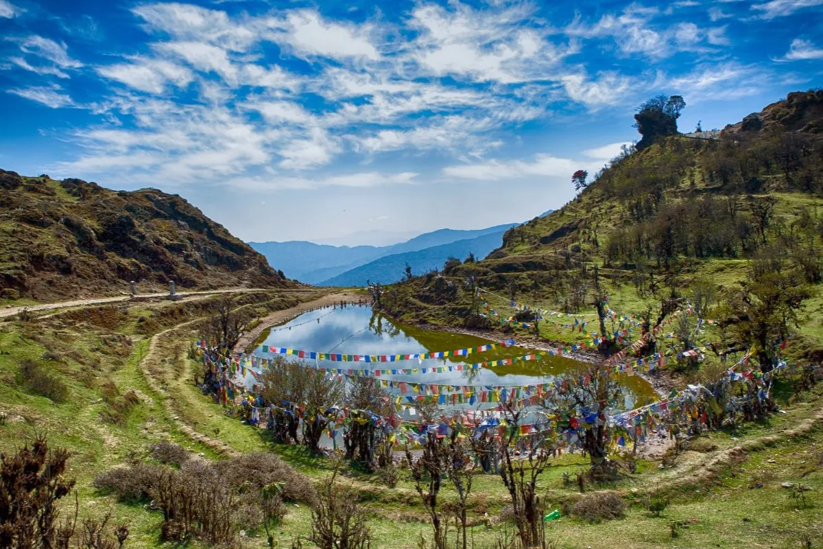 Lines of prayer flags strung along a bare Himalayan ridge under clear sky